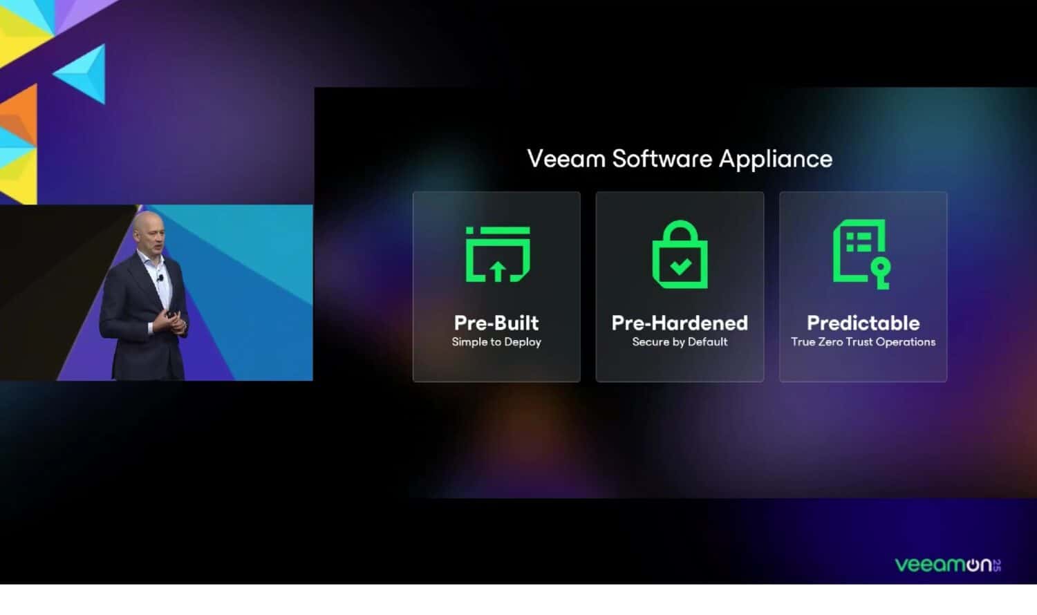 Een presentator staat bij een scherm waarop drie functies van Veeam Software Appliance worden weergegeven: Pre-Built, Pre-Hardened en Predictable, elk met een bijbehorend groen pictogram.